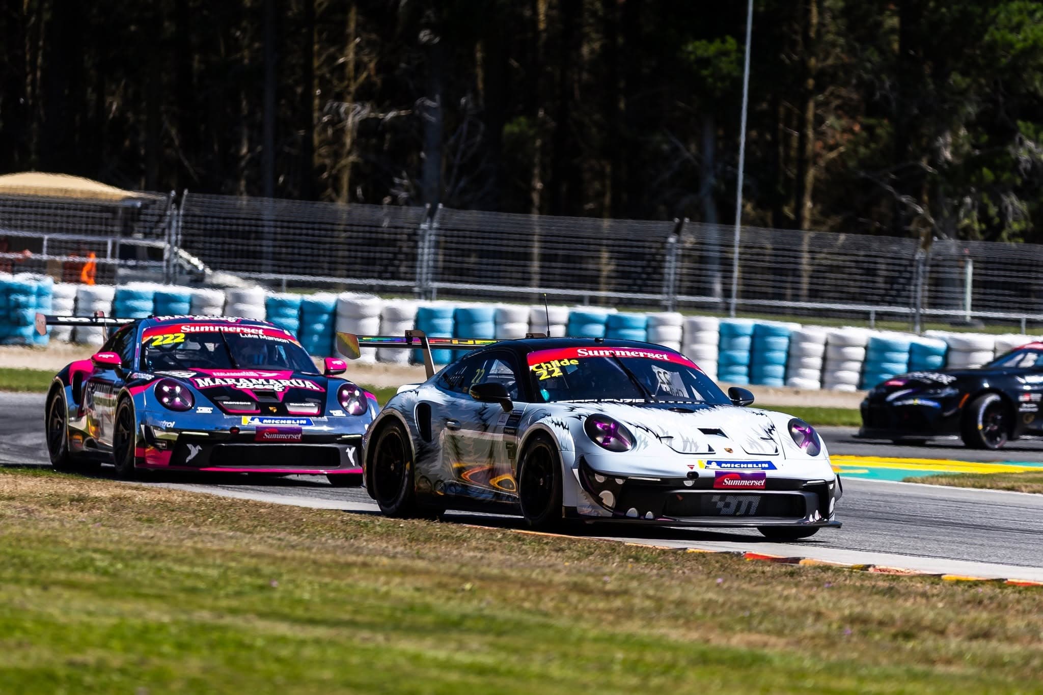 Porsche GT3 Cup cars battle side by side past Summerset trackside banners